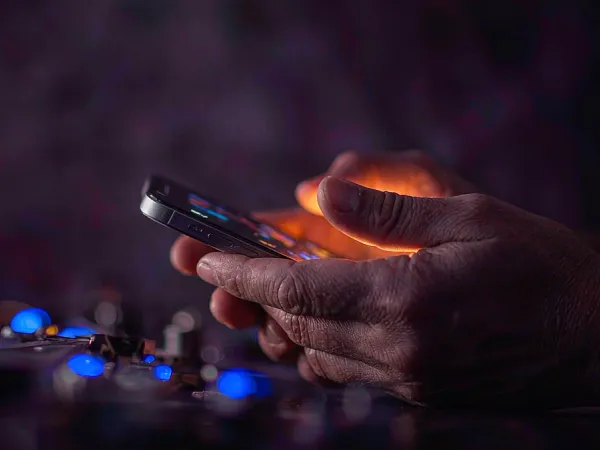 m444 Hands holding a smartphone in warm light