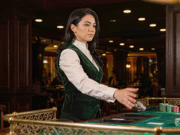 m444 Dealer reveals cards at a baccarat table with neat chip stacks