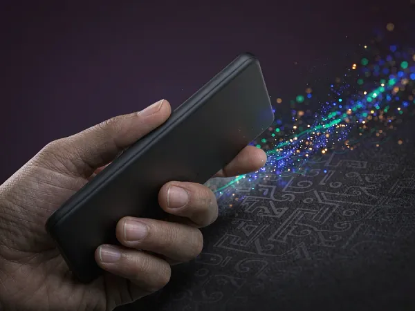 m444 Hand holds a smartphone with colourful light particles