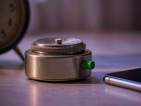 m444 Small timer beside a smartphone